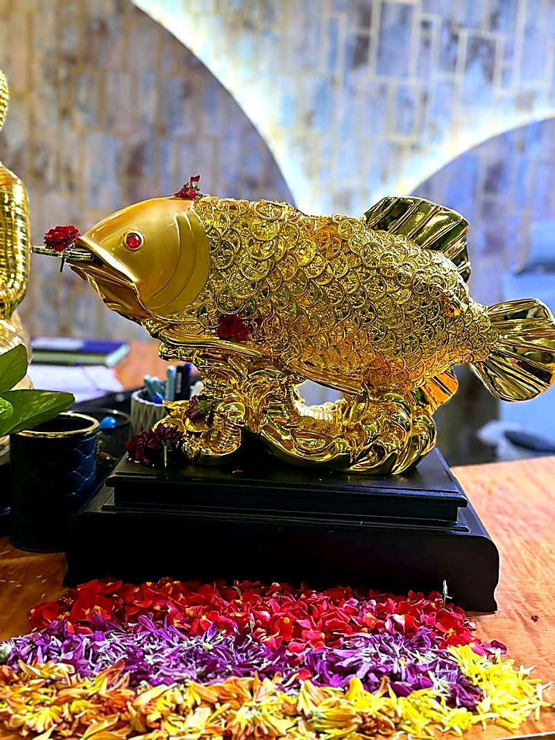 Decorative gold statue and floral display at reception